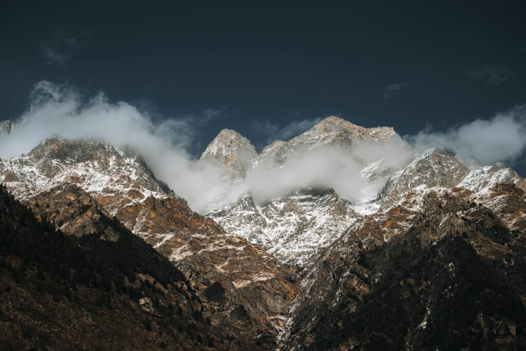 Stunning view of snow-covered Himalayan mountains with clouds and dramatic sky.